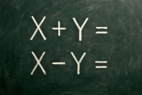 tableau noir avec equations simples x plus y et x moins y ecrites a la craie