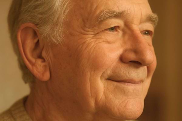 portrait rapproche dun homme age souriant legerement avec regard paisible