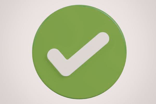 un symbole rond vert avec une coche blanche au centre sur fond clair