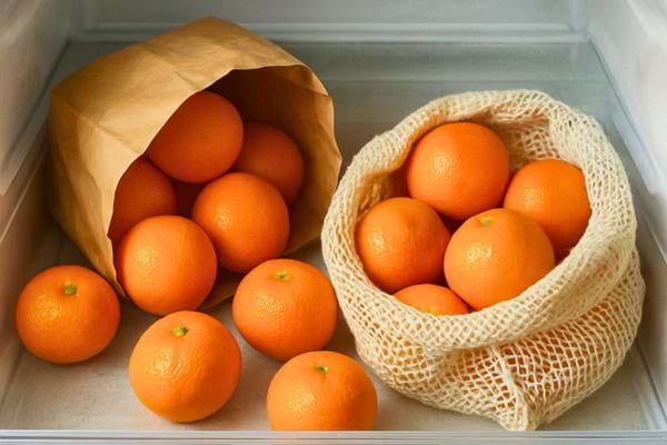 Mandarines conservees dans un sac en papier et un filet a l interieur du refrigerateur