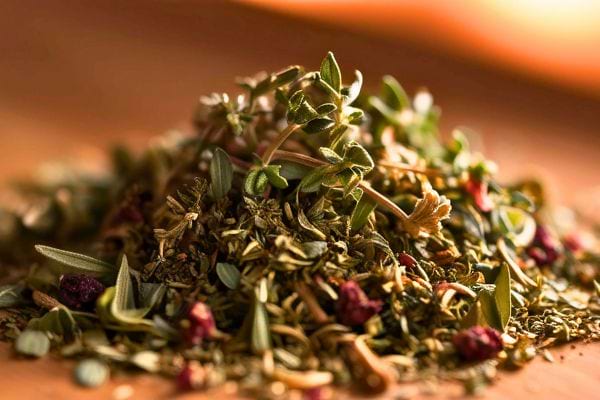 un tas dherbes sechees et de petites fleurs est dispose sur une table en bois