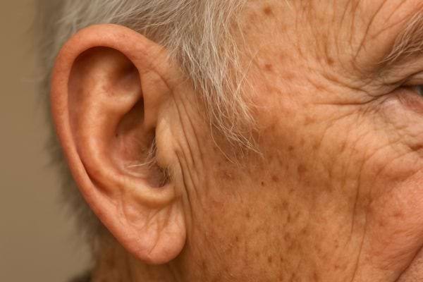 gros plan sur oreille dun homme age avec rides et taches visibles