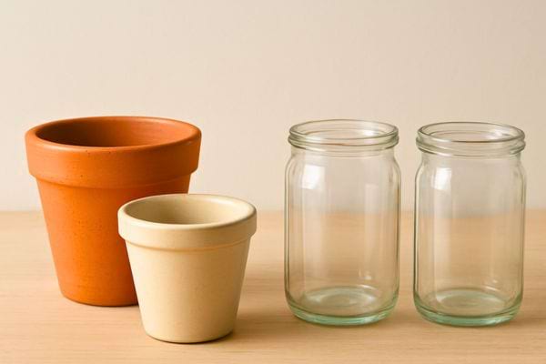 deux bocaux en verre et deux pots en terre cuite poses sur une table