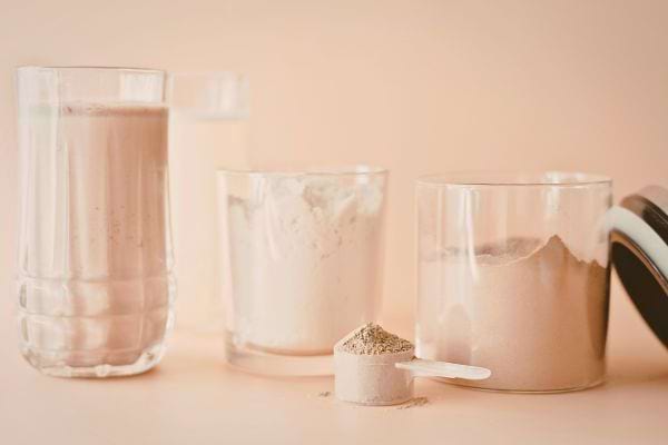 des pots de poudre et un verre deau sont poses sur une table avec une dosette