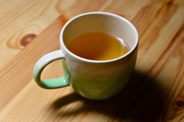 tasse de the chaud posee sur une table en bois avec lumiere douce