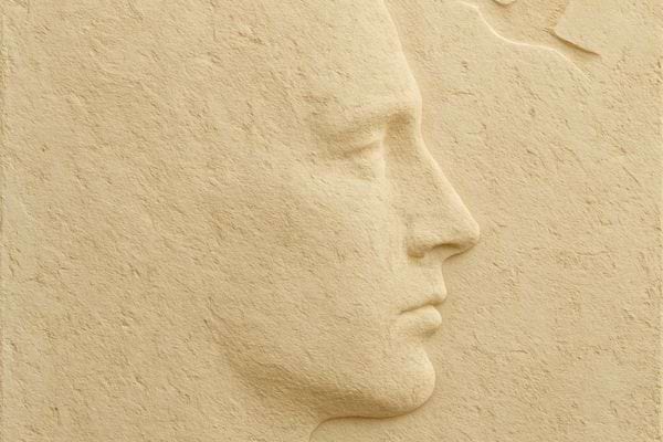 Profil dun visage sculpte dans un mur clair texture pierre