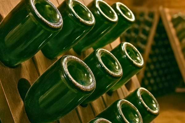 plusieurs bouteilles de vin rangees dans un casier en bois de cave