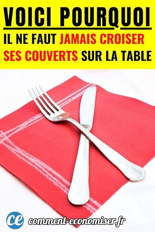 un couteau et une fourchette en inox argent&eacute; pos&eacute;s crois&eacute;s sur une serviette rouge