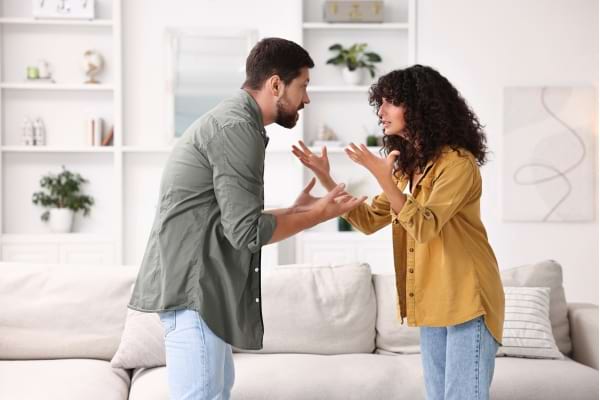 Une dispute de couple dans un salon lumineuse.