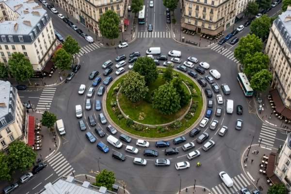 view of a busy classic French roundabout, many cars navigating