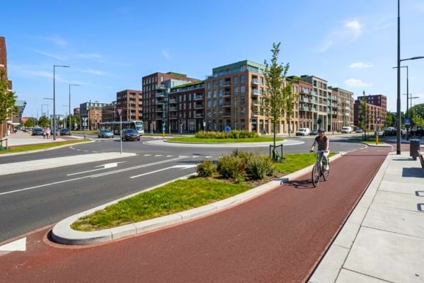 Realistic street level view of a modern Dutch-style roundabout