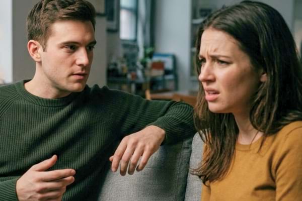 un jeune couple assis, le jeune homme regarde la femme avec une expression s&eacute;rieuse et autoritaire