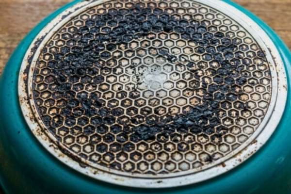 A top-down view of the bottom of a turquoise frying pan.