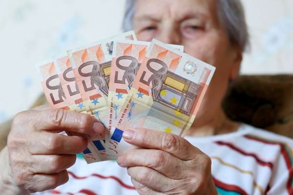 Une femme âgée qui tient des euros dans sa main