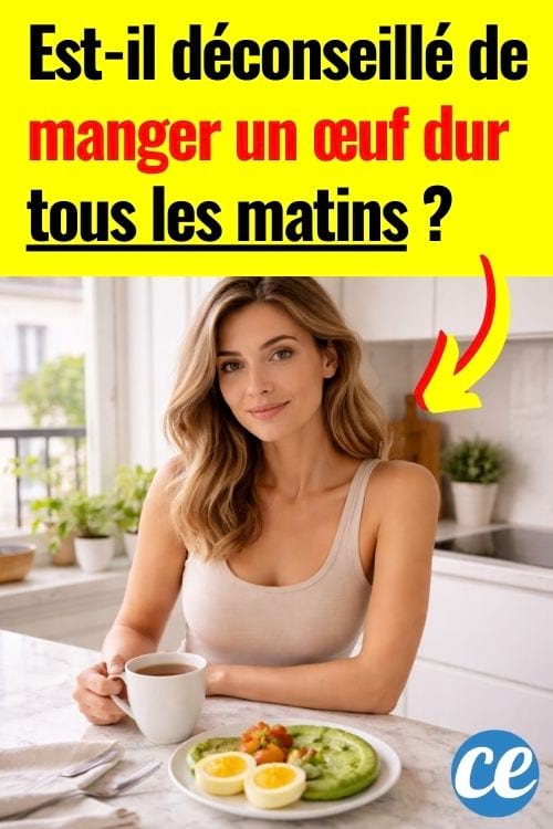 Femme souriante à table dans une cuisine lumineuse, buvant un café avec une assiette d’avocat et œufs.