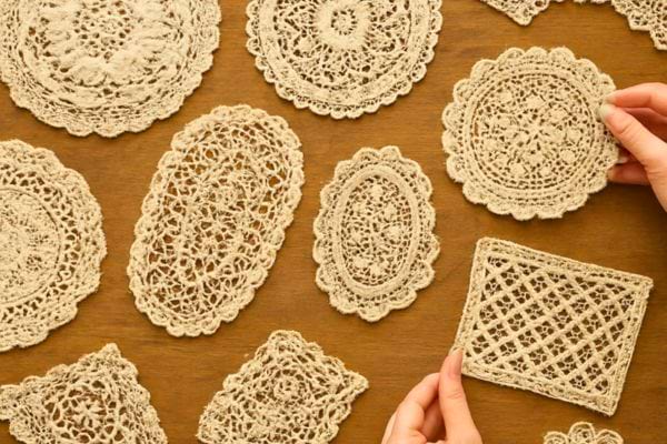 plusieurs napperons en dentelle sont poses sur une table en bois