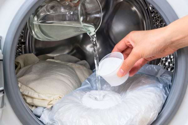 liquide et poudre ajoutes dans une machine a laver pour nettoyer le linge