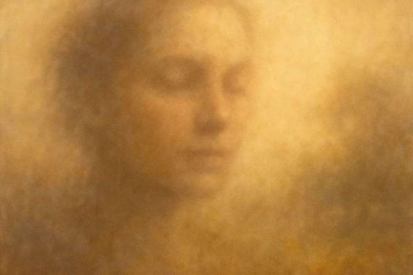un visage feminin apparait flou dans une brume aux tons chauds et dores