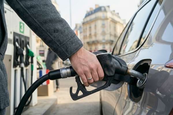 main tenant le pistolet de pompe &agrave; essence ins&eacute;r&eacute; dans le r&eacute;servoir