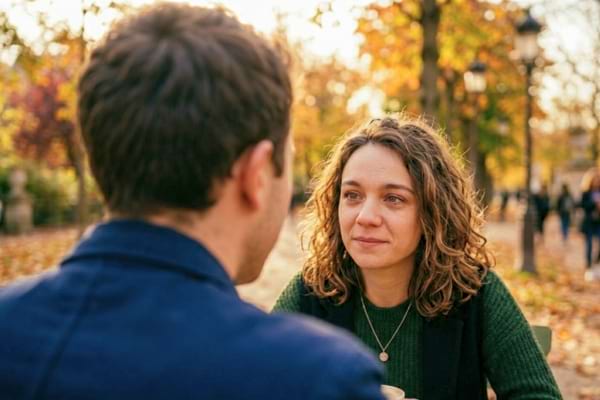 close up over the shoulder shot of a man listening intently to his date, soft eye contact,
