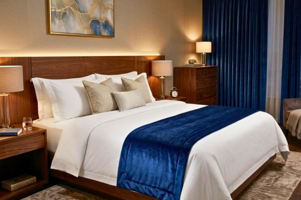 un lit king size aux draps blancs qui contrastent avec un magnifique chemin de lit