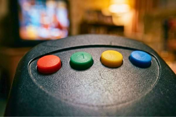 quatre touches color&eacute;es (rouge, vert, jaune, bleu) d'une t&eacute;l&eacute;commande moderne en plastique noir mat.