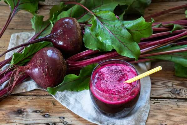 Un verre de jus de betteraves avec une paille