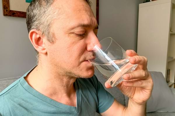 Homme qui boit de l'eau pour arr&ecirc;ter les flatulences