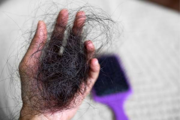 Une femme qui perd des cheveux le matin