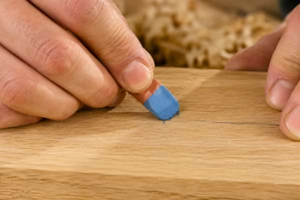 un artisan menuisier en train d'effacer une marque de crayon &agrave; papier sur une belle planche de bois