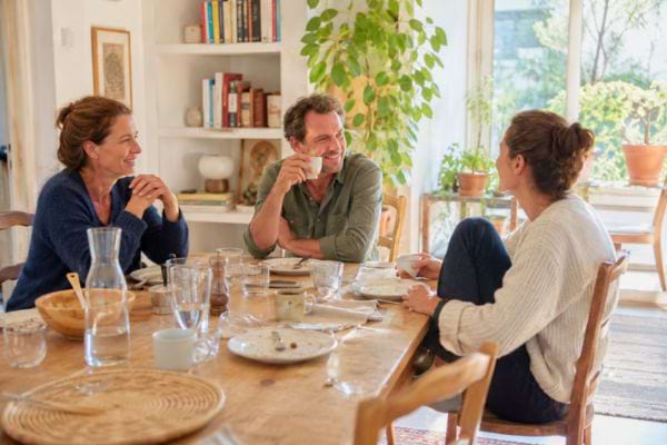 Famille discutant autour d&rsquo;une table apr&egrave;s un repas.