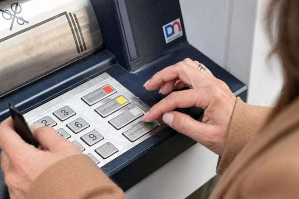une femme appuie sur une touche du distributeur automatique