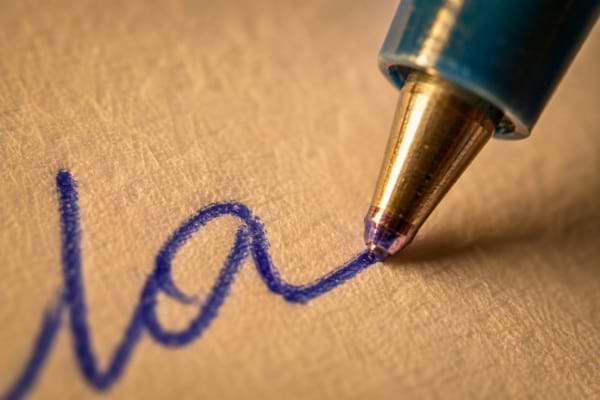 une pointe de stylo &agrave; bille bleu &eacute;crivant sur un papier textur&eacute;