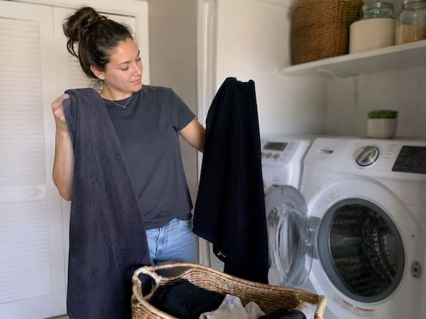 Une femme compare deux serviettes foncées après une lessive