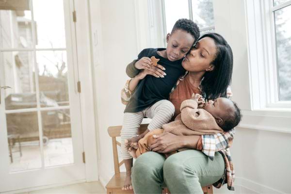une maman embrasse son fils avec son b&eacute;b&eacute;