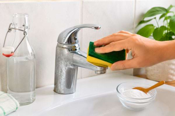 Robinet nettoyé avec une éponge et du bicarbonate.