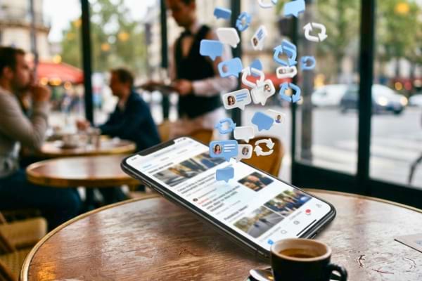 un fil d'actualité flou avec des icônes de commentaires et de partages qui s'envolent de l'écran.
