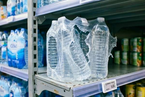 Un pack de six bouteilles d'eau en plastique dont le film transparent a été grossièrement déchiré