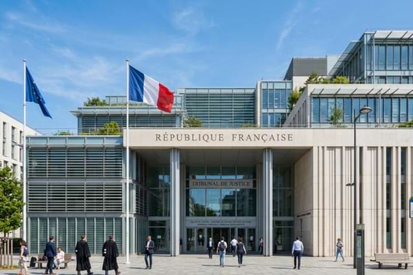 fa&ccedil;ade d'un palais de justice fran&ccedil;ais moderne avec des colonnes et le drapeau fran&ccedil;ais