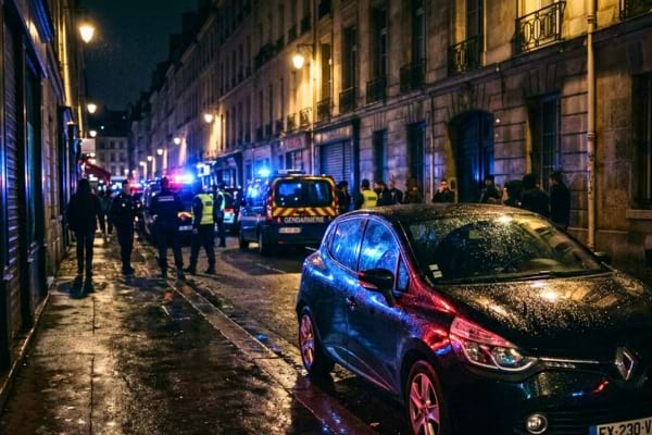 une voiture de ville avec les reflets bleus et rouges de gyrophares de police sur la carrosserie.