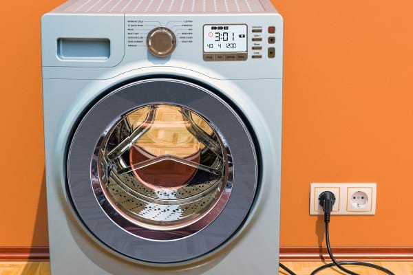 Une prise &eacute;lectrique &agrave; cot&eacute; d'une machine &agrave; laver