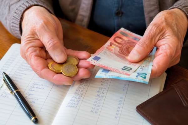 mains rid&eacute;es tenant des pi&egrave;ces de monnaie et des billets en euros