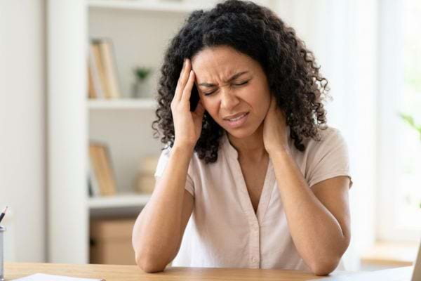 Femme souffrant d&rsquo;un fort mal de t&ecirc;te, mains sur les tempes