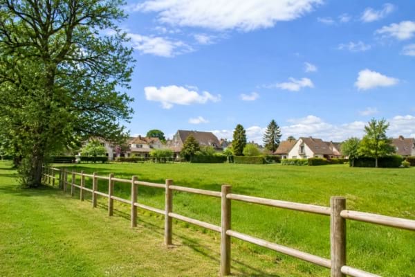 un grand champ vert paisible en bordure d'une zone pavillonnaire
