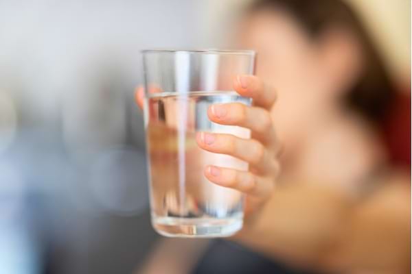 Une personne qui tient un verre d'eau