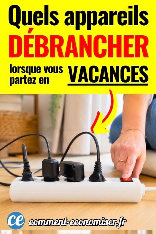 Main éteignant une multiprise avec plusieurs appareils branchés.