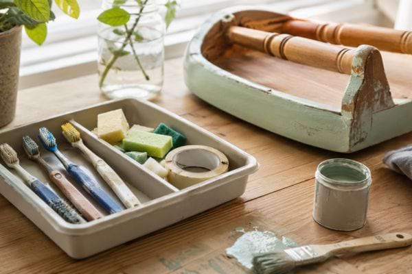 Mini-applicateur maison utilisé pour repeindre un pied de chaise et un cadre déco.