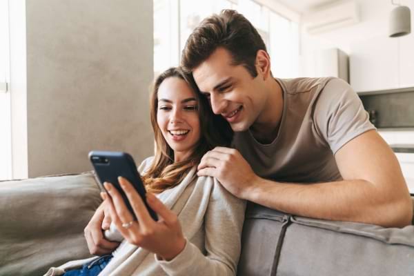 Couple regardant un smartphone pour choisir prénom