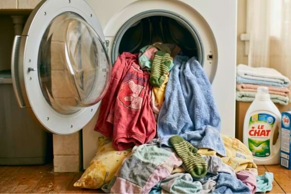 un tas de linge coloré délavé sortant d'une machine à laver