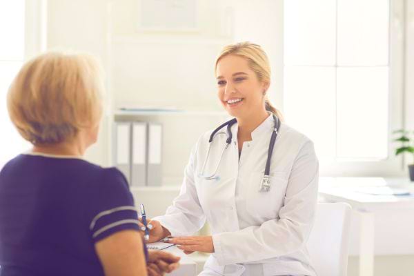une femme de dos consulte une femmme médecin
